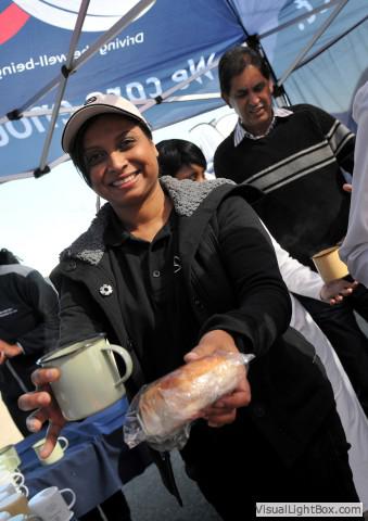 a mbsa employee volunteer handing out soup